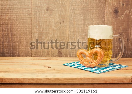 Oktoberfest german beer festival  background with beer glass and pretzel on wooden table