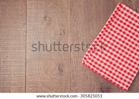 Abstract wooden texture background with red checked tablecloth. View from above