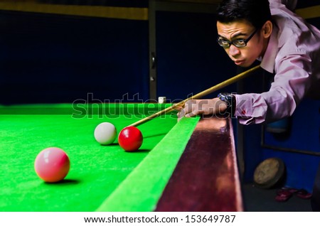 Snooker player placing the cue ball for a shot (Focus on ball,blur on player face and motion blur)