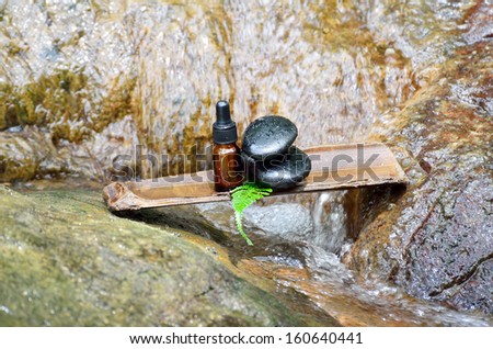 Zen stone with spa oil in SPA concept at waterfall
