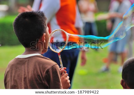 PAHANG, MALAYSIA - MARCH 29, 2014 : Kids playing with giant bubble at Putrajaya Hot Balloon Fiesta 2014 located at Putrajaya, Malaysia.