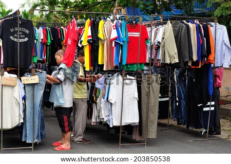 MALAYSIA - JULY 6 : Clothes hanging on a rack in a flea market on July 6, 2014 near Beserah, Kuantan, Pahang, Malaysia. Beserah market are open to public every Monday evening
