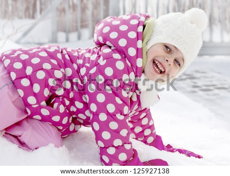 Happy child girl having fun in the snow - winter time