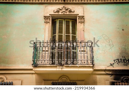 Old building elevation - vintage balcony, shutters and ornaments. South Europe town, historic architecture details.