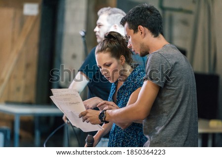 Behind the scene. Director of the play rehearses the play with the actors according to the script