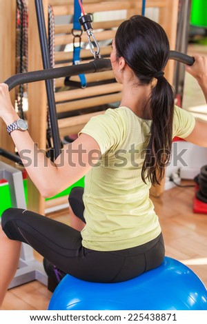 Pretty young woman practicing in the gym. A young woman in a health club
