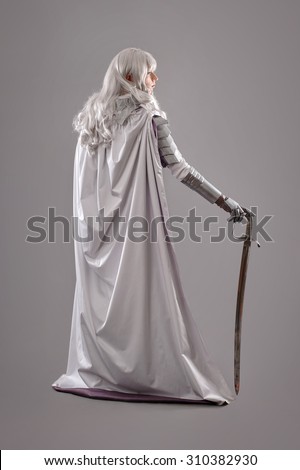 Female Knight In Shining Armour with sword isolated on the gray background