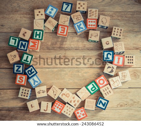 Wooden block alphabet lay on wooden floor in circle shape