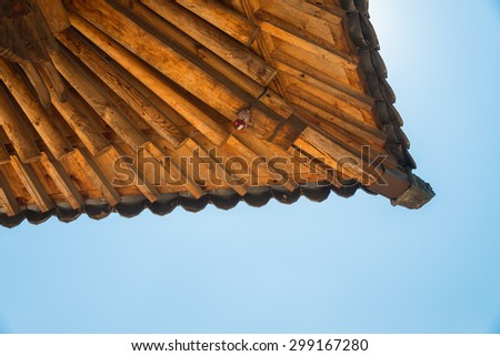 Corner of wooden roof in Korean style with IP camera