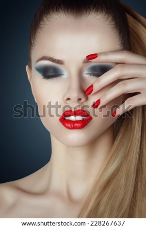 beautiful woman with bright glamour make-up. Red lips and nails. Blonde hair. Clean skin.