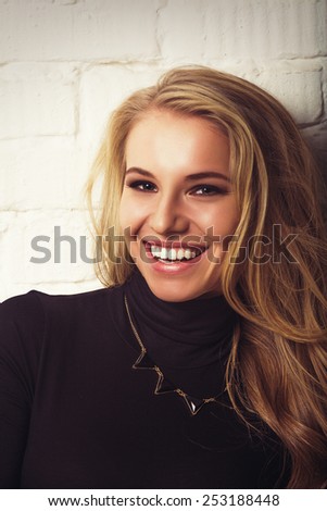 Smiling young attractive blonde woman. Fun good expression lifestyle. Vintage soft effect photo.