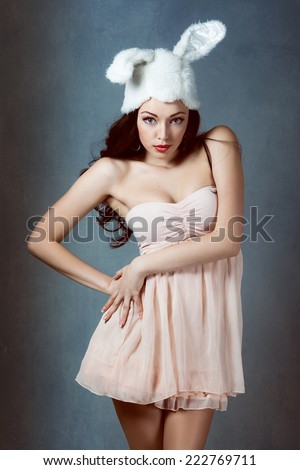 Beautiful sexy woman with long silky hair posing, girl in the image of the rabbit in  pink dress bad bunny sly sexy look play boy for men