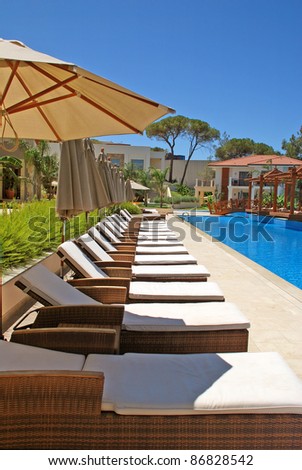 line of chaise lounges for tan by the pool