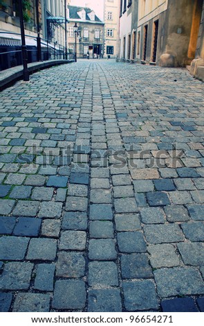 Diminishing view of old european street with cobblestone close-up(Vienna,Austria). Selective focus