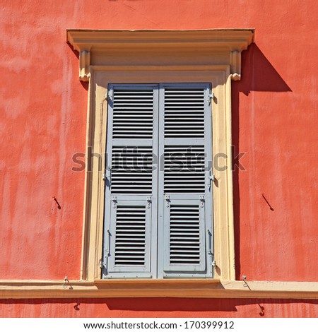 typical old grey french shutter window in red house of Nice, Cote d\'azur, France. Square shape image