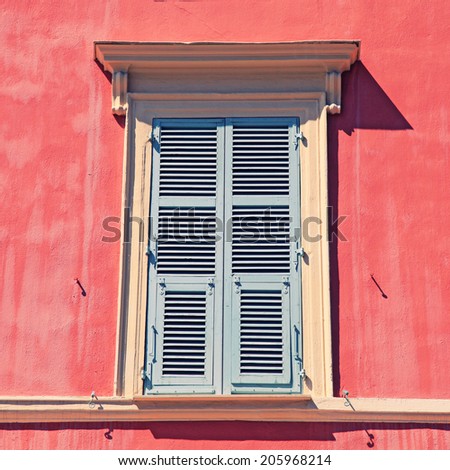 typical old grey french shutter window in red house of Nice, Cote d\'azur, France. Square toned image