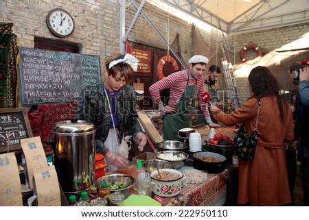 KIEV, UKRAINE - OCTOBER 11, 2014: Unidentified people cook and trades traditional dishes of Odessa restaurant on food stall and giving away TV interview  in Street Food Festival in Kiev, Ukraine.