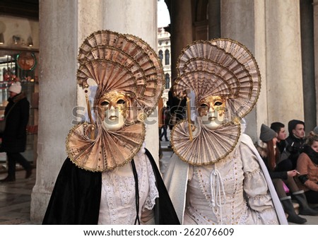 VENICE, ITALY - FEBRUARY 7, 2015: Two unidentified masked persons in costume on San Marco Square during the Carnival in Venice, Italy.