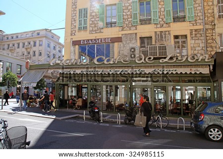 NICE, FRANCE - MAY 13, 2013: Outdoor french cafe in old building on the main city street - Jean Medecin Avenue in Nice,France. Sun beams