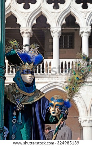 VENICE, ITALY - FEBRUARY 8, 2015: Costumed people in Venetian mask on the Piazza San Marco during Venice Carnival in Venice, Italy. Selective focus