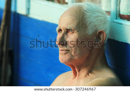 portrait of an old man with a gray head with the wisdom of looking into the distance