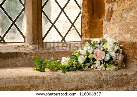 Summer wedding bouquet laid within church entrance.