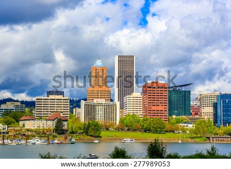 Portland, Oregon - April 25, 2015: Portland downtown skyline showing Wells Fargo Center and KOIN Center, behind Willamette river and waterfront park.