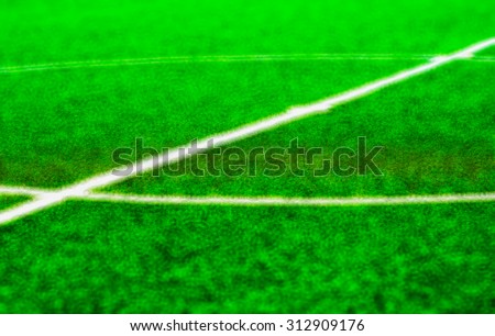 Diagonal white line on center of green football pitch bokeh background