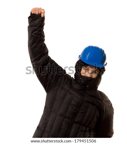 Young teenage thug in a black hoodie and hardhat punching the air with his fist in a sign of aggression and victory, isolated on white