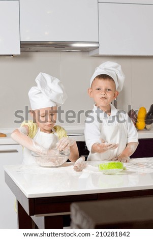 Cute White Little Chefs Baking on White Wooden Table in the Kitchen
