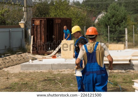 Team of builders or workmen on site at a new build house construction installing the insulated wooden wall panels