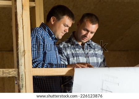 Two Middle Age Building Architects Reviewing Building Blueprint at the Site Seriously.
