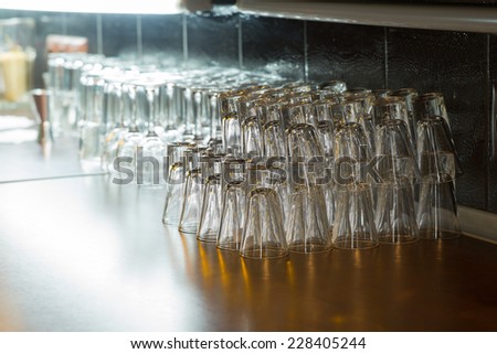 Various Empty Clean Beverage Glasses Piled in Upside Down on Wooden Table at the Bar