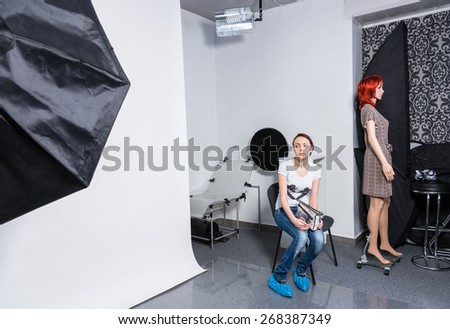 Serious Young Woman in Casual Clothing Sitting on a Chair at the Photo Studio While Waiting for Something.