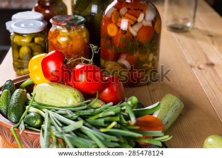 Still Life of Bounty of Fresh Vegetables and Jars of Pickles on Wooden Table