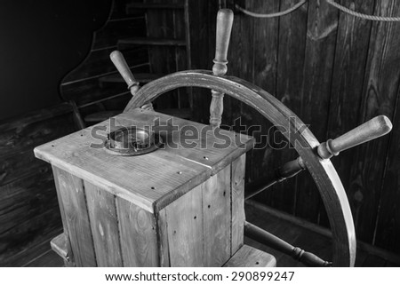 Detail of Antique Wooden Steering Helm with Wheel and Compass, Black and White Image of Historical Sailing Ship