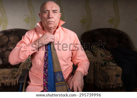 Handsome old man trying on several ties