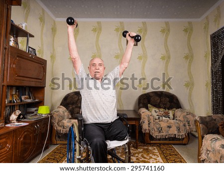 Invalid old man puts his hands up with dumbbells