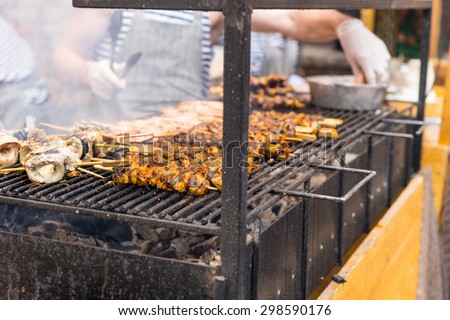 Close Up of Unidentifiable People Cooking Meat Skewers Over Smoking Hot Barbecue Grill