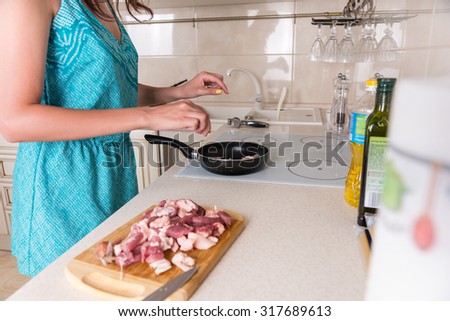 Close Up of Unidentifiable Woman Preparing Meal - Cooking Sliced Raw Meat in Hot Frying Pan on Stove Top