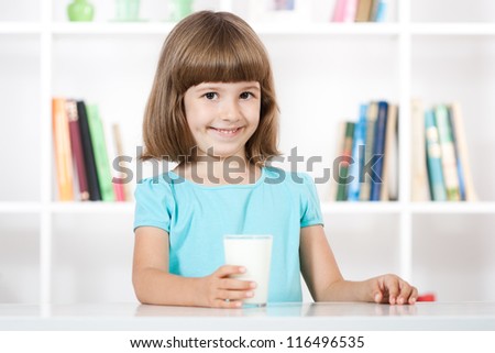 Little girl holding glass of milk in her hand,Little girl with glass of milk