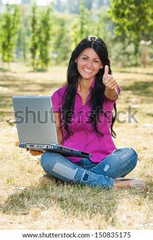 Beautiful woman using laptop and showing thumb up,Woman using laptop