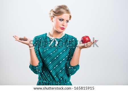Retro woman is angry because she has to eat fruit,she would rather eat chocolate,Tired of dieting