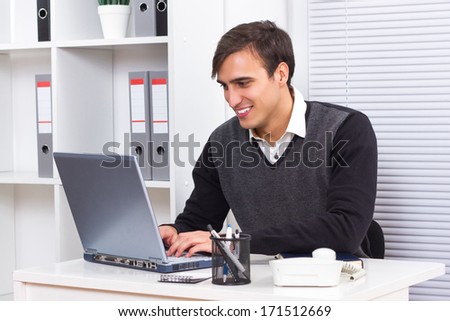 Young businessman sitting in his office and working on his laptop,Businessman using laptop