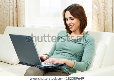 Beautiful  woman sitting on sofa at her home and using laptop at her home,Woman using laptop