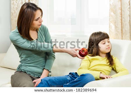 Mother is giving fruit to her daughter to eat but she is very angry,she don`t like fruit,I don`t want to eat fruit!