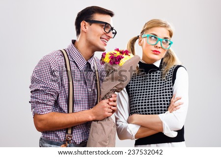 Nerdy man is giving  a bouquet of flowers to his girlfriend,he had made a mistake and he is hoping that she will forgive him,Please forgive me my dear!