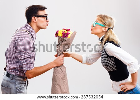 Young nerdy man is giving a bouquet of flowers to his nerdy lady,Flowers for my nerdy lady!