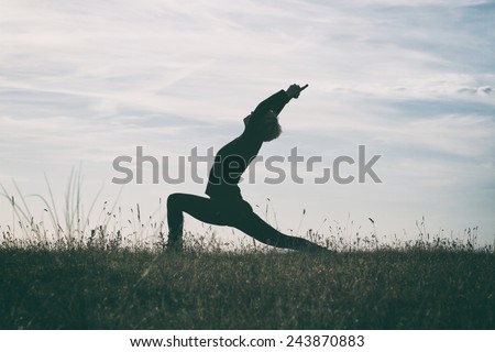 Woman practicing yoga,intentionally toned image.Yoga-Virabhadrasana /Warrior pose