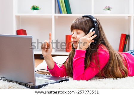 Cute little girl with headphones is listening music.I love this song!